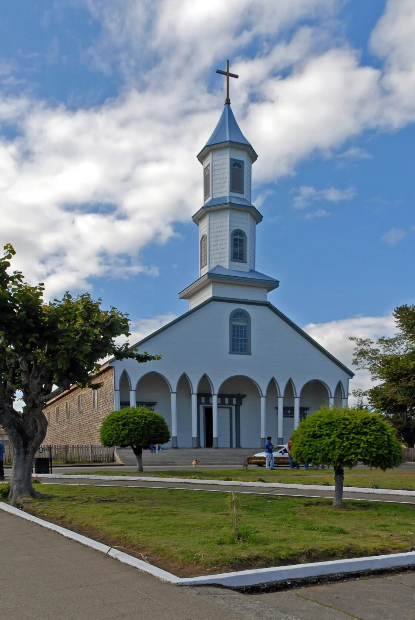 푸른 구름 낀 하늘을 배경으로 한 교회의 세로 사진